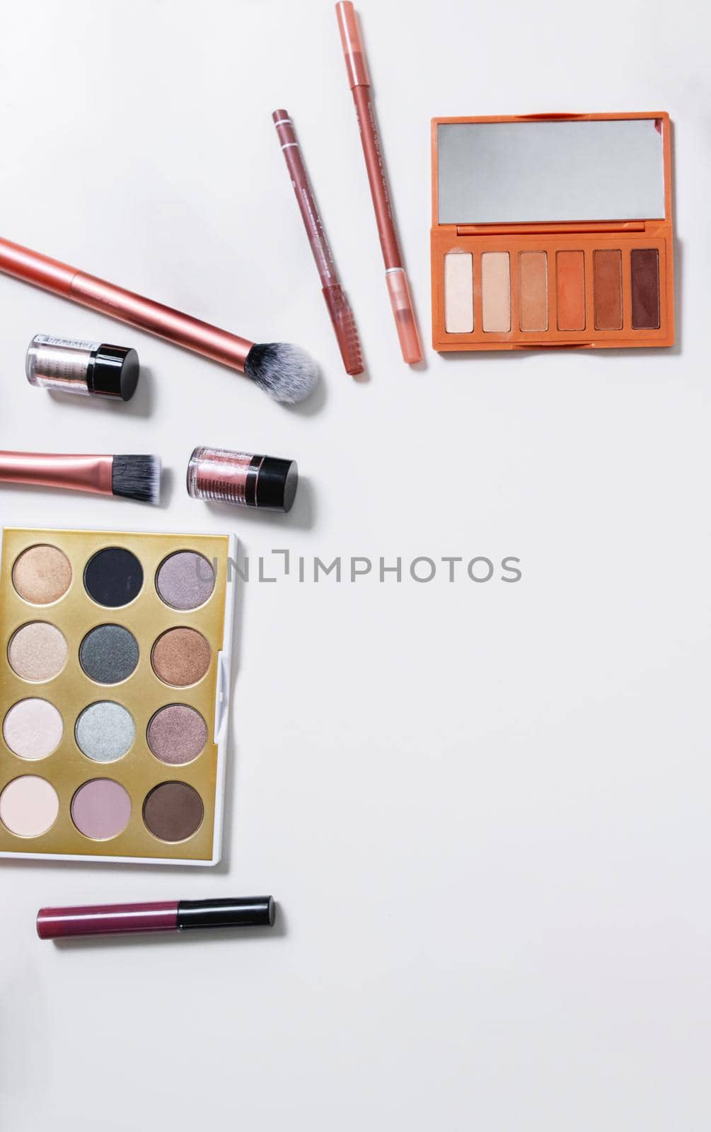 Decorative flat lay composition with cosmetics and flowers. Flat lay, top view on white background