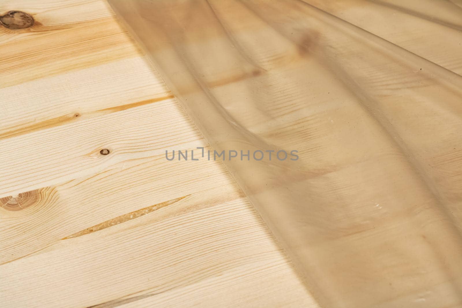 Wooden board in cellophane packaging close up, copy space