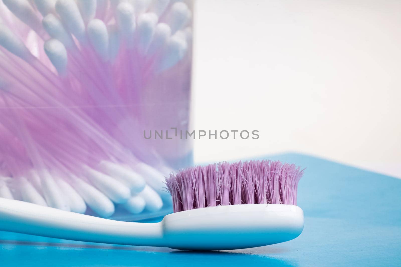 Cotton buds and toothbrush on the table in the bathroom close up