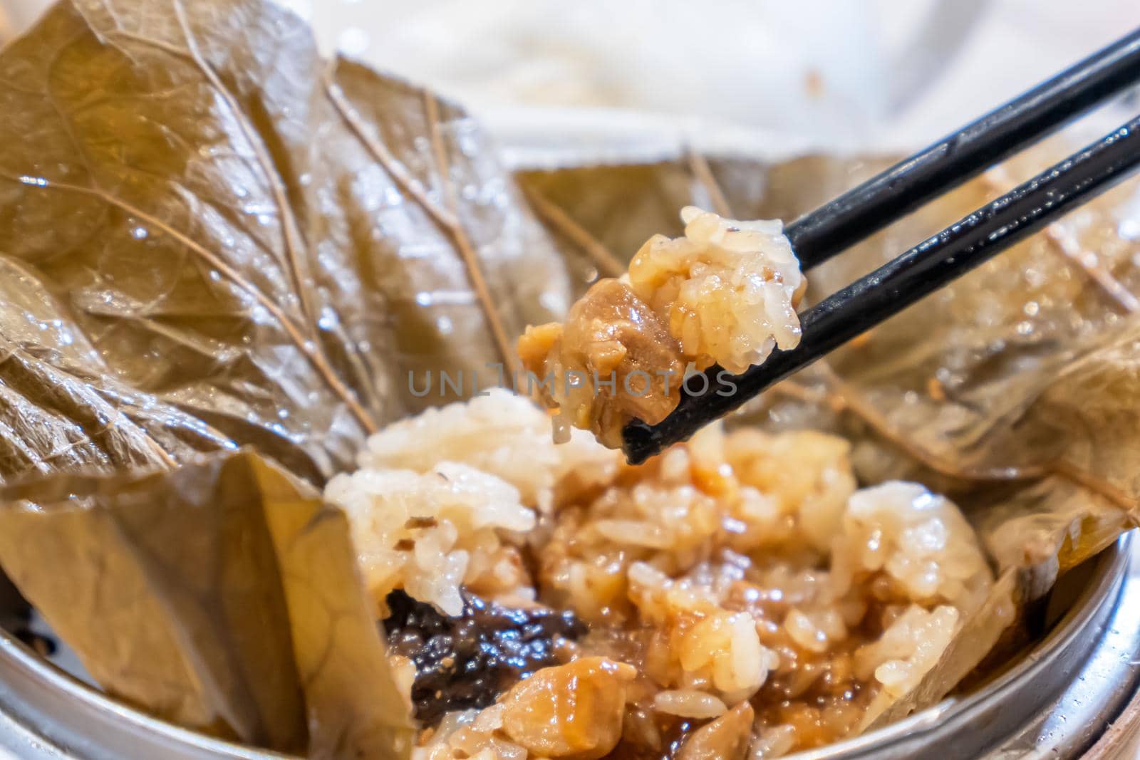 Delicious Lo Mai Gai dim sum, fresh steamed glutinous rice with chicken roll wrapped by lotus leaf in bamboo steamer in hong kong yumcha restaurant.