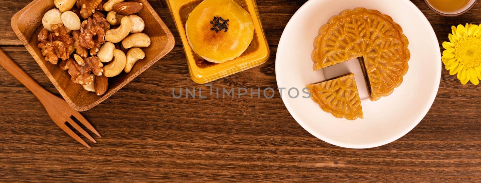 Mid-Autumn Festival holiday concept design of moon cake, mooncakes, tea set on dark wooden table with copy space, top view, flat lay, overhead shot by ROMIXIMAGE