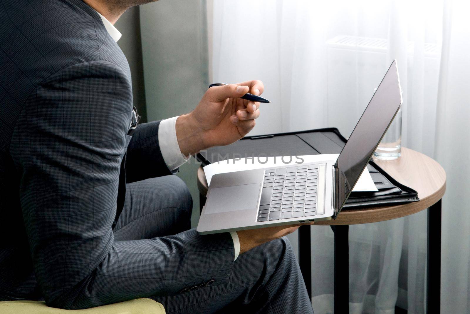 Young businessman working on laptop, sitting in hotel