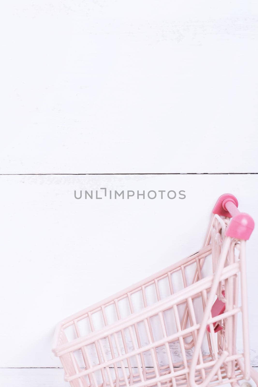 Abstract design element, annual sale, shopping season concept, mini cart with colorful paper bag on white wooden table background, top view, flat lay