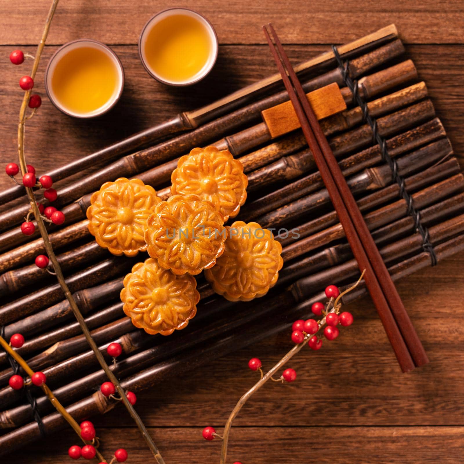 Chinese traditional pastry Moon cake Mooncake with tea cups on bamboo serving tray on wooden background for Mid-Autumn Festival, top view, flat lay.