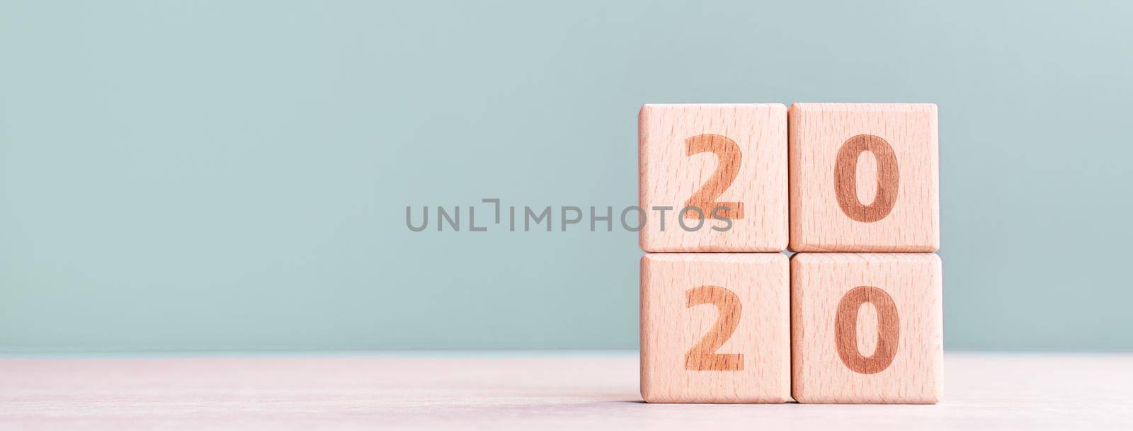 Abstract 2020, 2019 New year target plan design concept - wood blocks cubes on wooden table and pastel green background, close up, blank copy space.