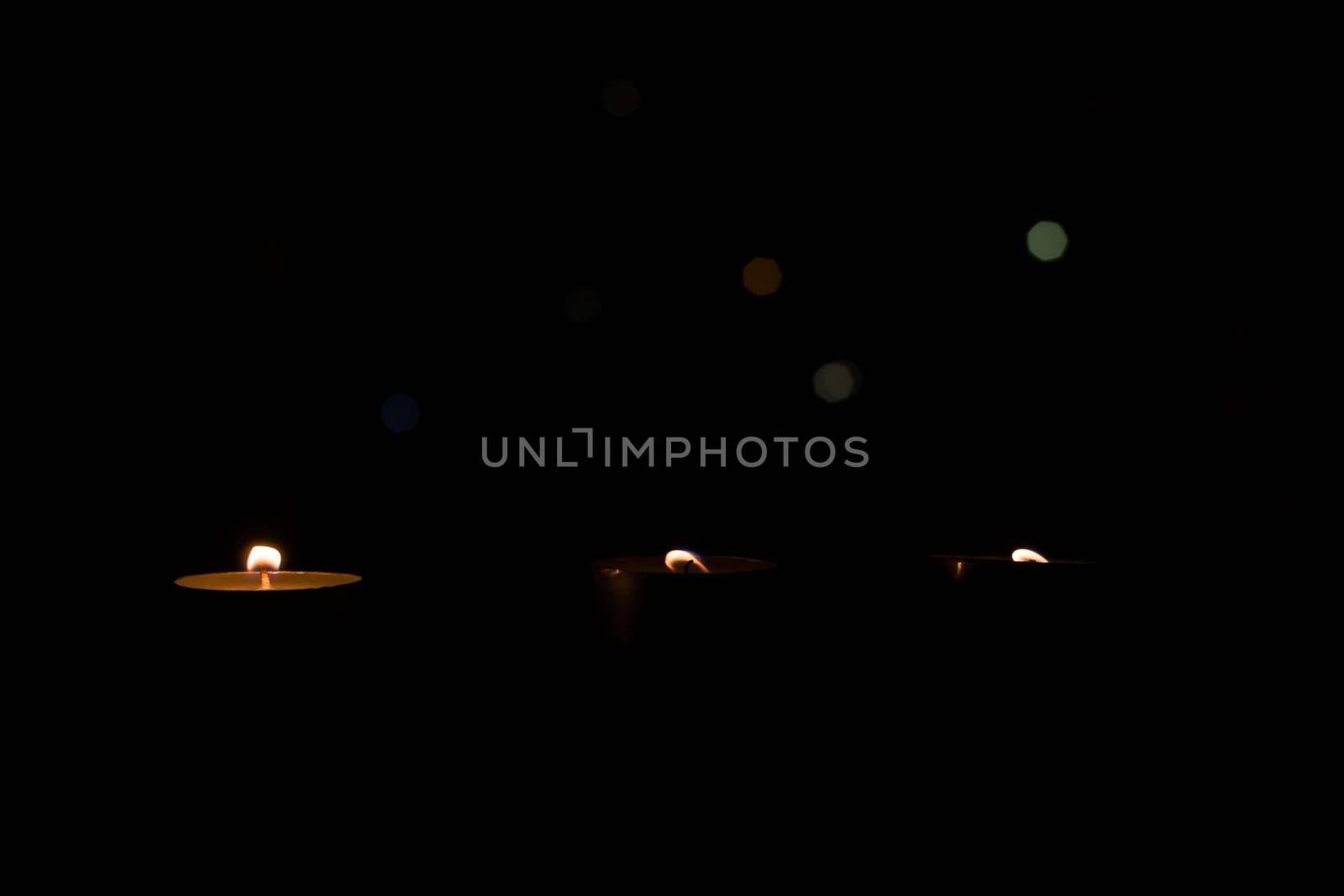 Three small candles in the dark closeup by Vera1703