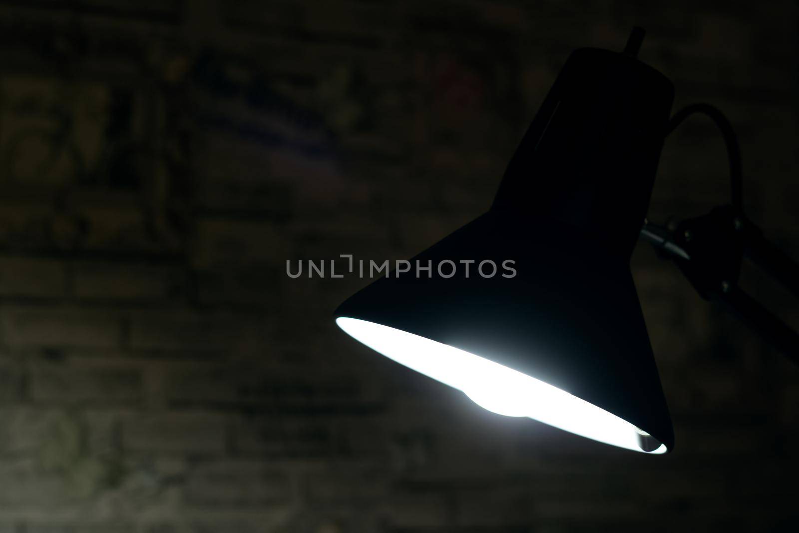 The light of a black table lamp in the dark, copy space
