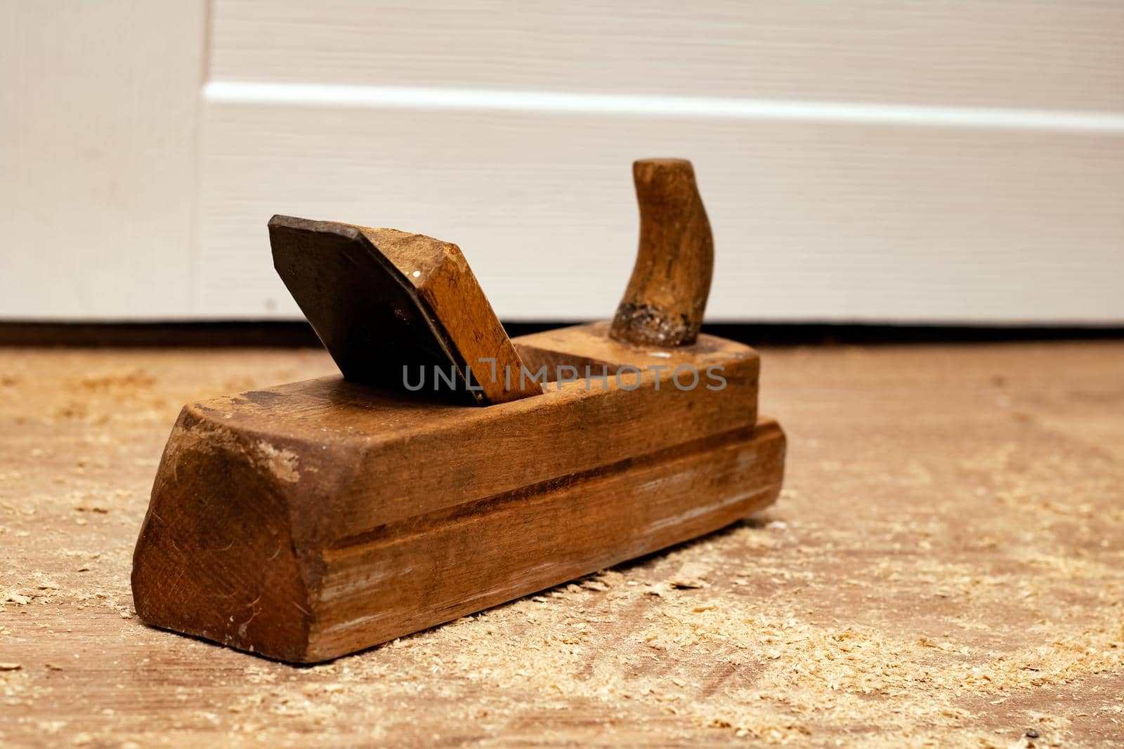 Retro wooden planer among sawdust on a wooden floor close up
