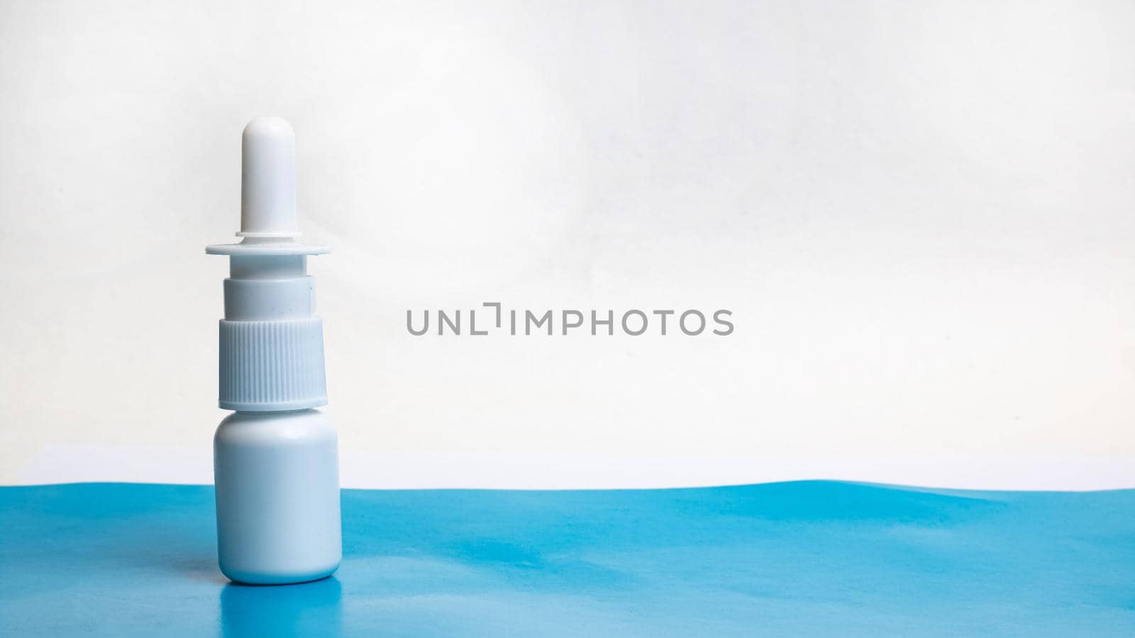 Drops for nose on a blue table, copy space
