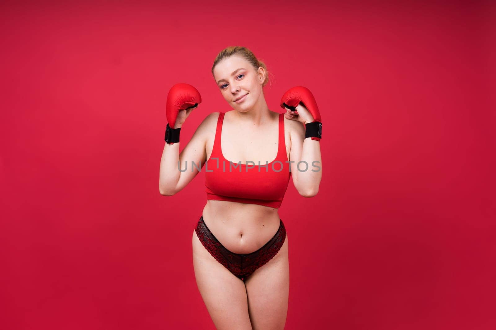 Boxer, seductive confident female boxer with gloves studio, sporty woman posing looking to camera.