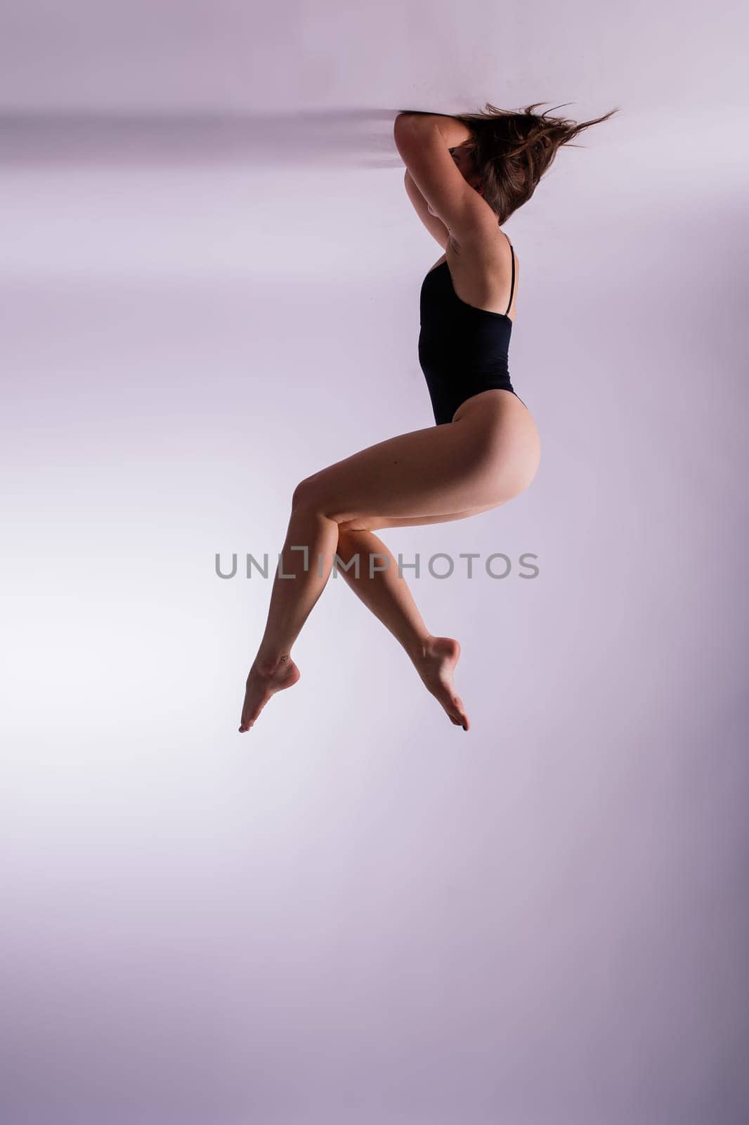 Image of a young plump female doing acrobatic stunt, studio shot