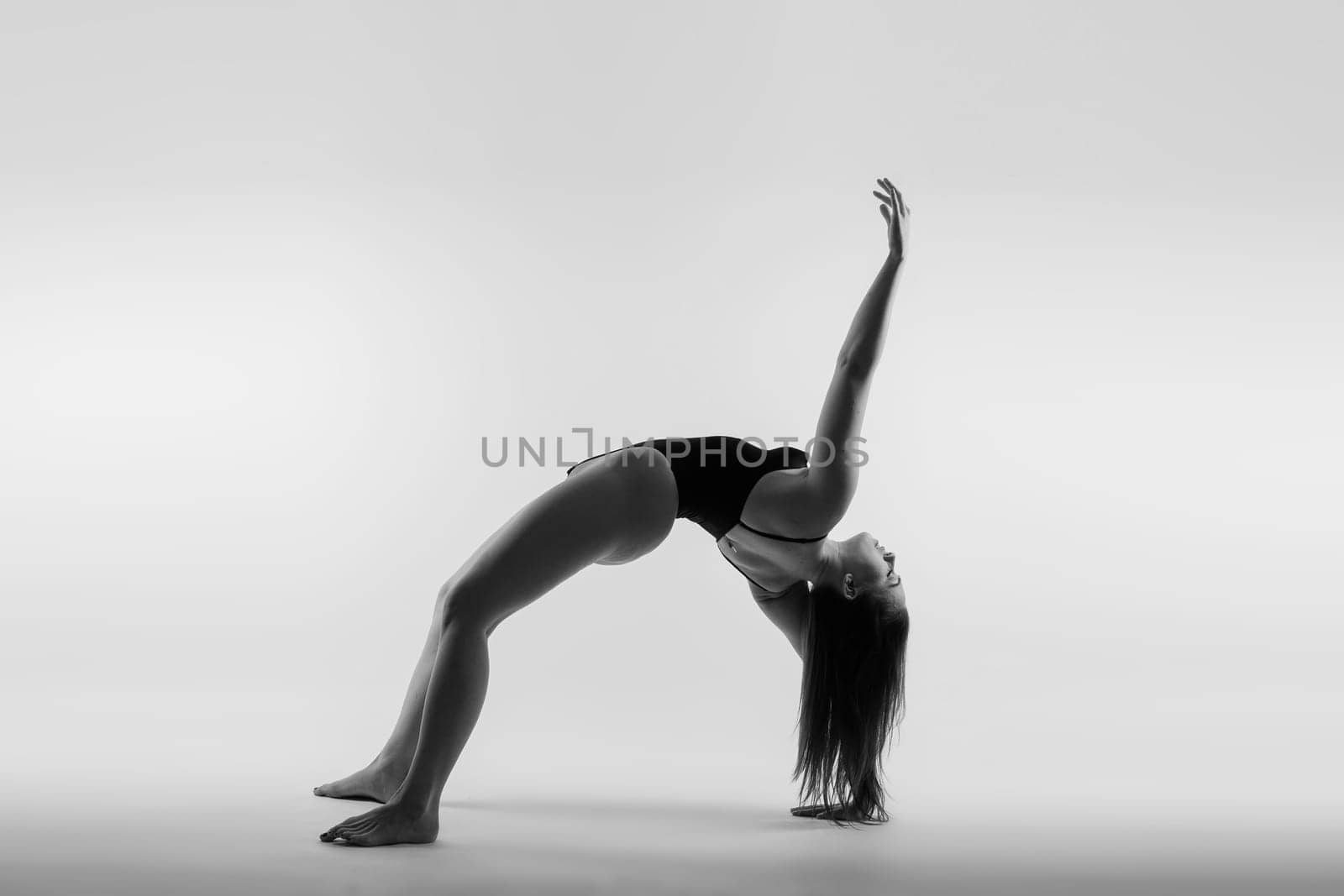 Image of a young plump female doing acrobatic stunt, studio shot