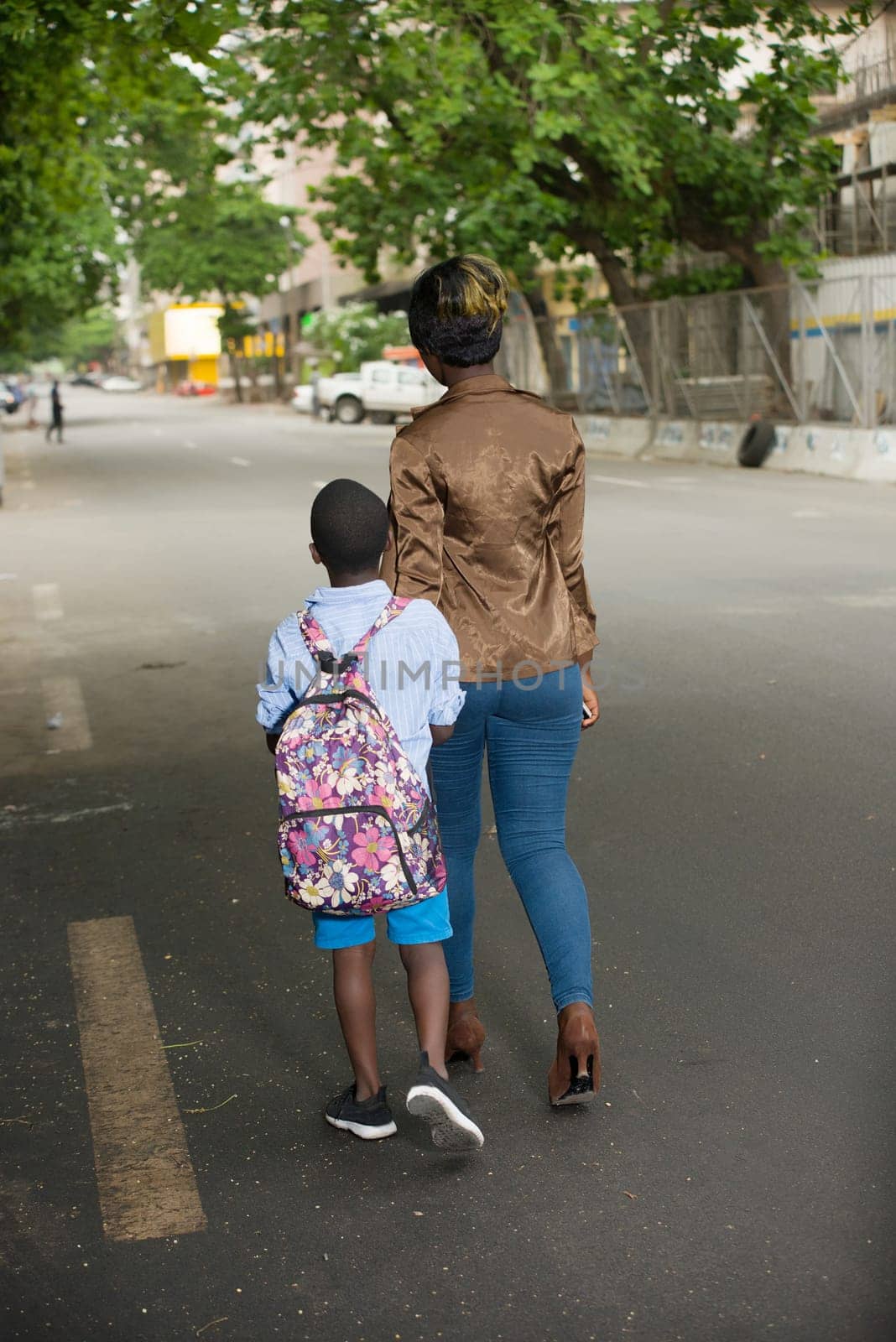 woman and son on the way to school. Child going back to school. Start of the new school year after the summer holidays. little boy with backpack returns to school accompanied by his mother. Beginning of the course