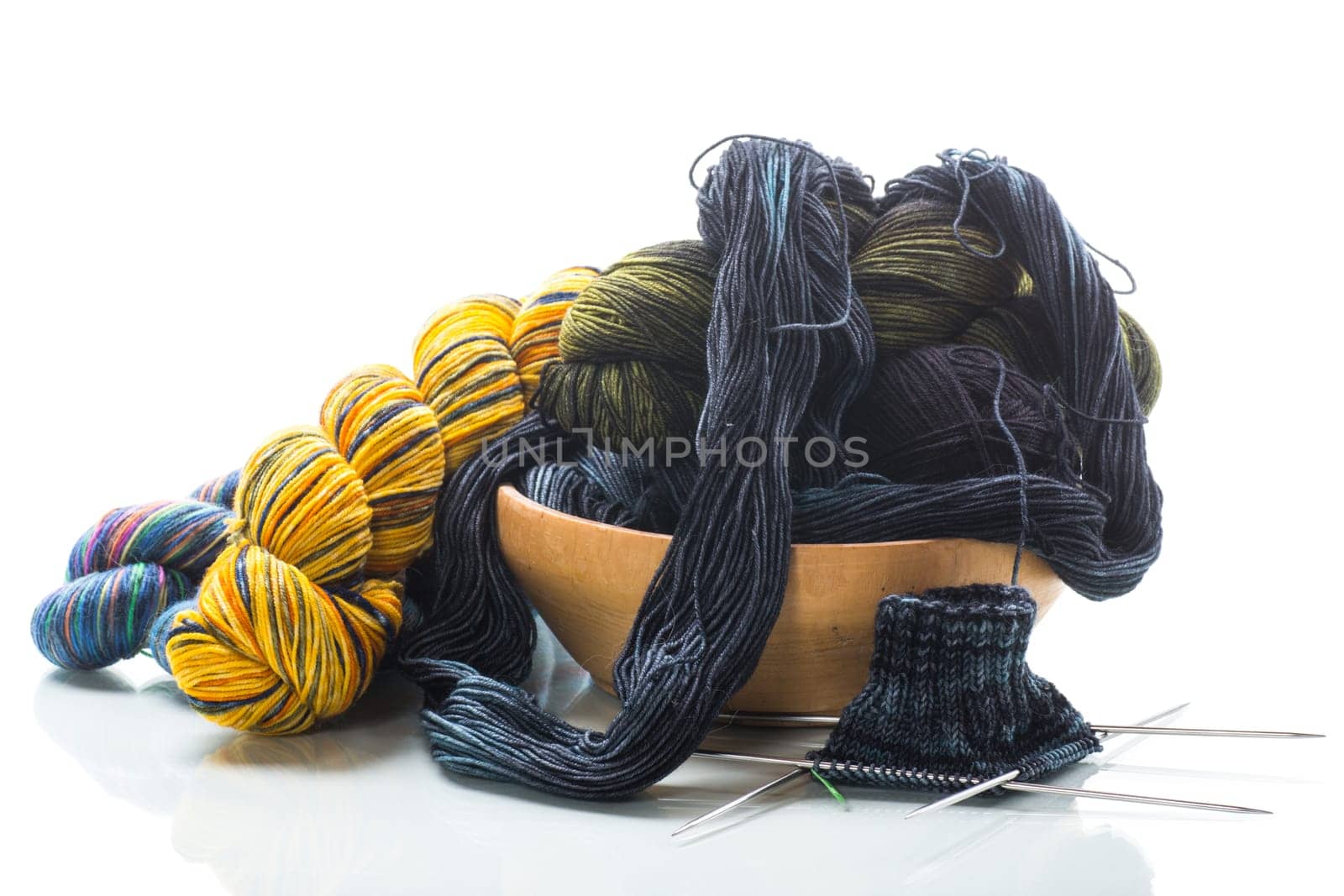 Colored threads, knitting needles and other items for hand knitting, isolated on a white background.