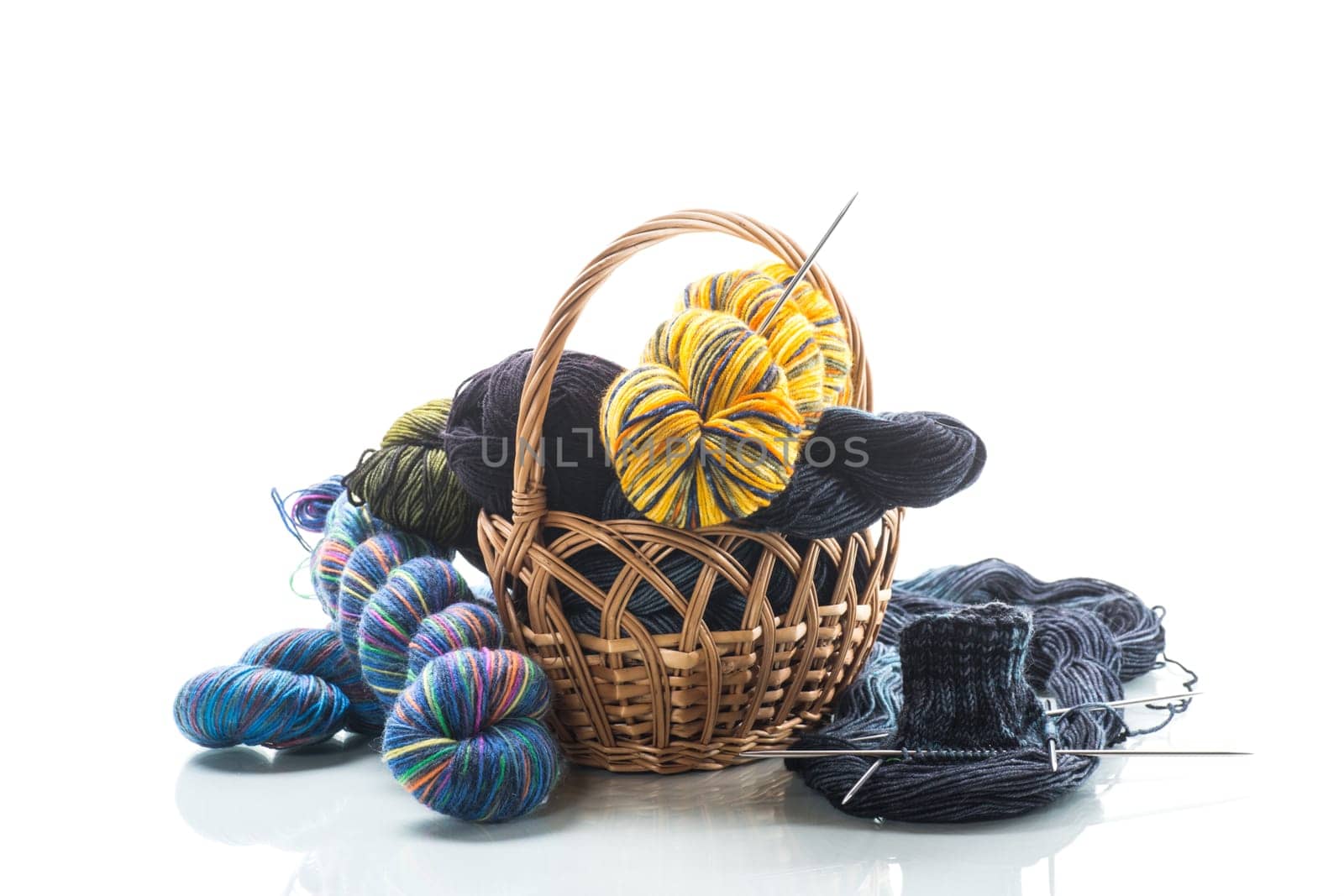 Colored threads, knitting needles and other items for hand knitting, isolated on a white background.