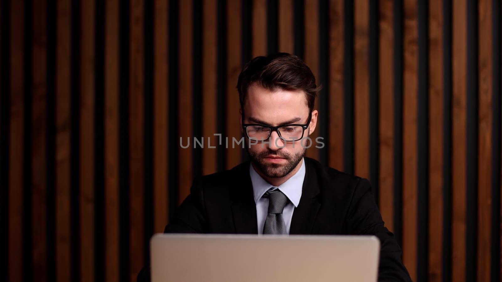 Shot of a young businessman using a computer at his desk in a modern office.