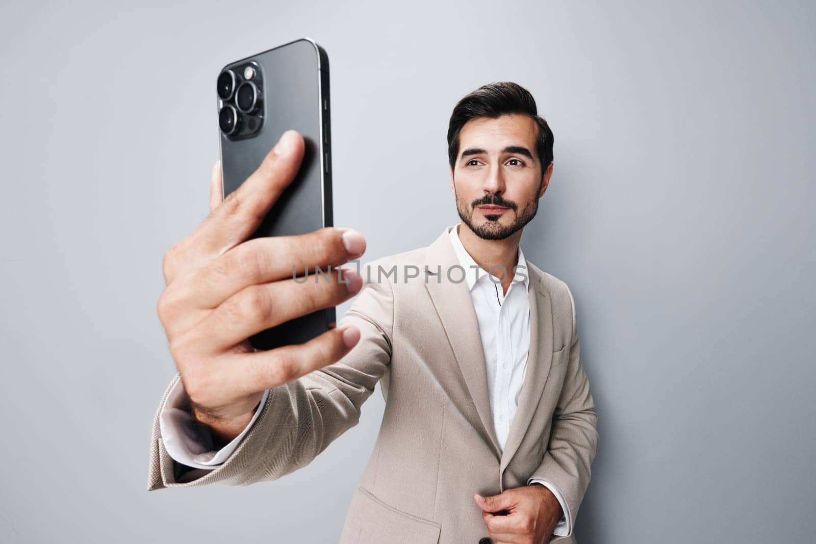 man cyberspace suit smartphone young copy smile confident call business beige space portrait success hold isolated app technology trading phone happy male