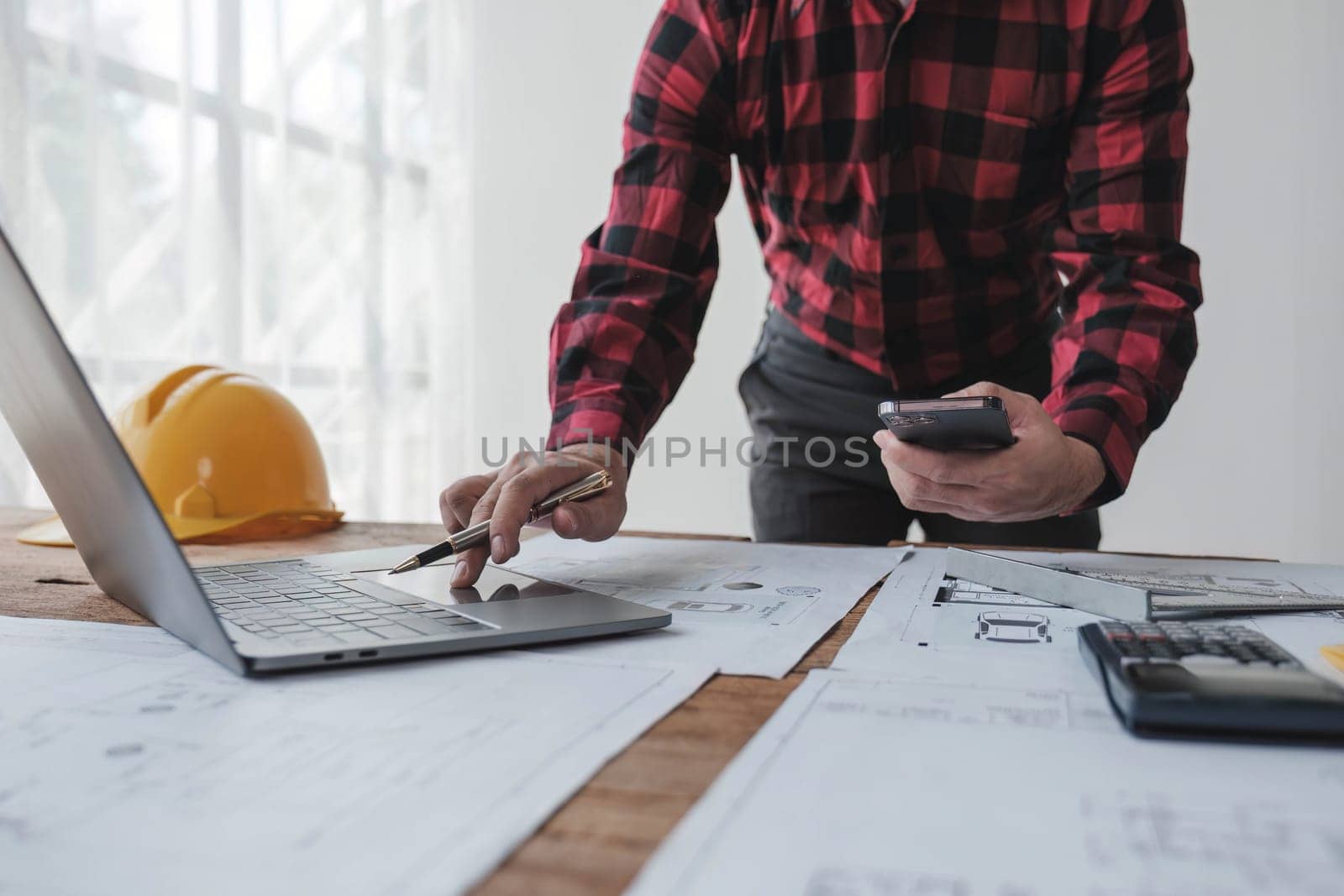 Concept architects, engineer holding pen pointing equipment architects On the desk with a blueprint in the office by wichayada