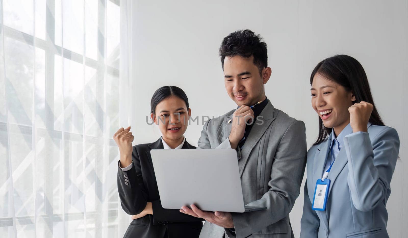 Solving problems as one team. Asian young team of male and female working together while sitting at their working place in office, enjoy, looking at the camera...