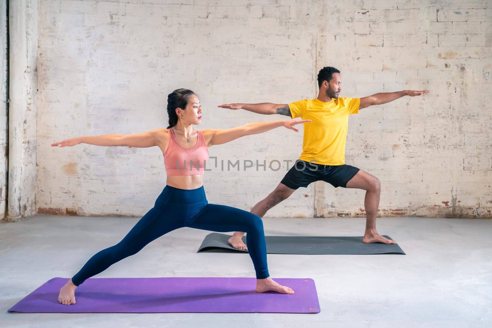 Mixed race sporty man and girl doing exercise. Multi ethnic couple On Mats Doing Yoga Exercises Together. High quality photo