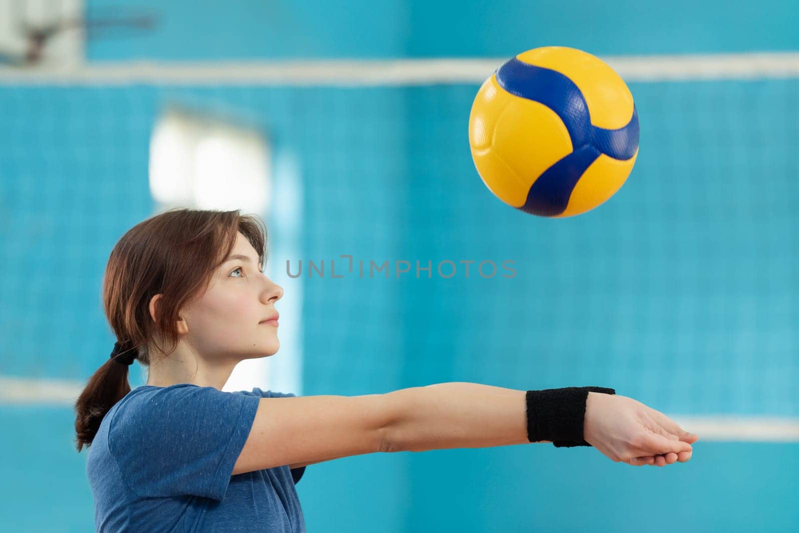 Girl practicing digging to receive and save the ball from hard-given attack of the opponents