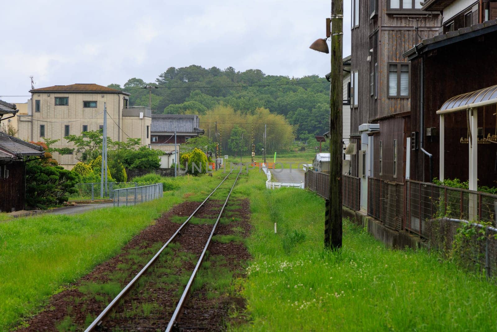 Train tracks by buildings in rural Japanese town by Osaze