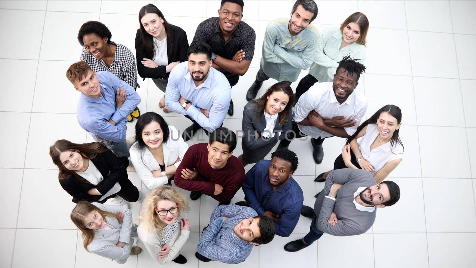 multicultural successful business group looking up in office corridor