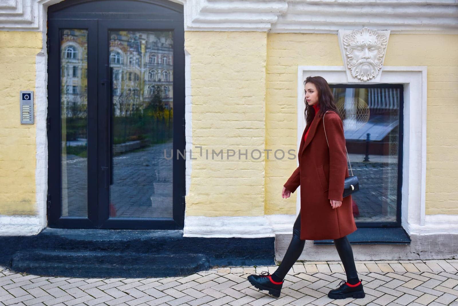 Woman with a concerned look on her face walks in a hurry down the street.