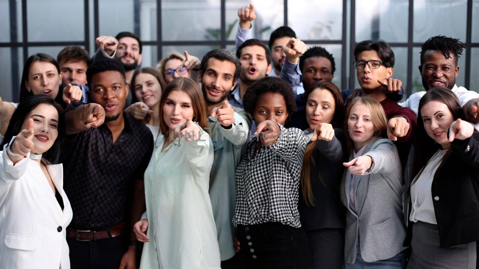 group of happy young people pointing at you
