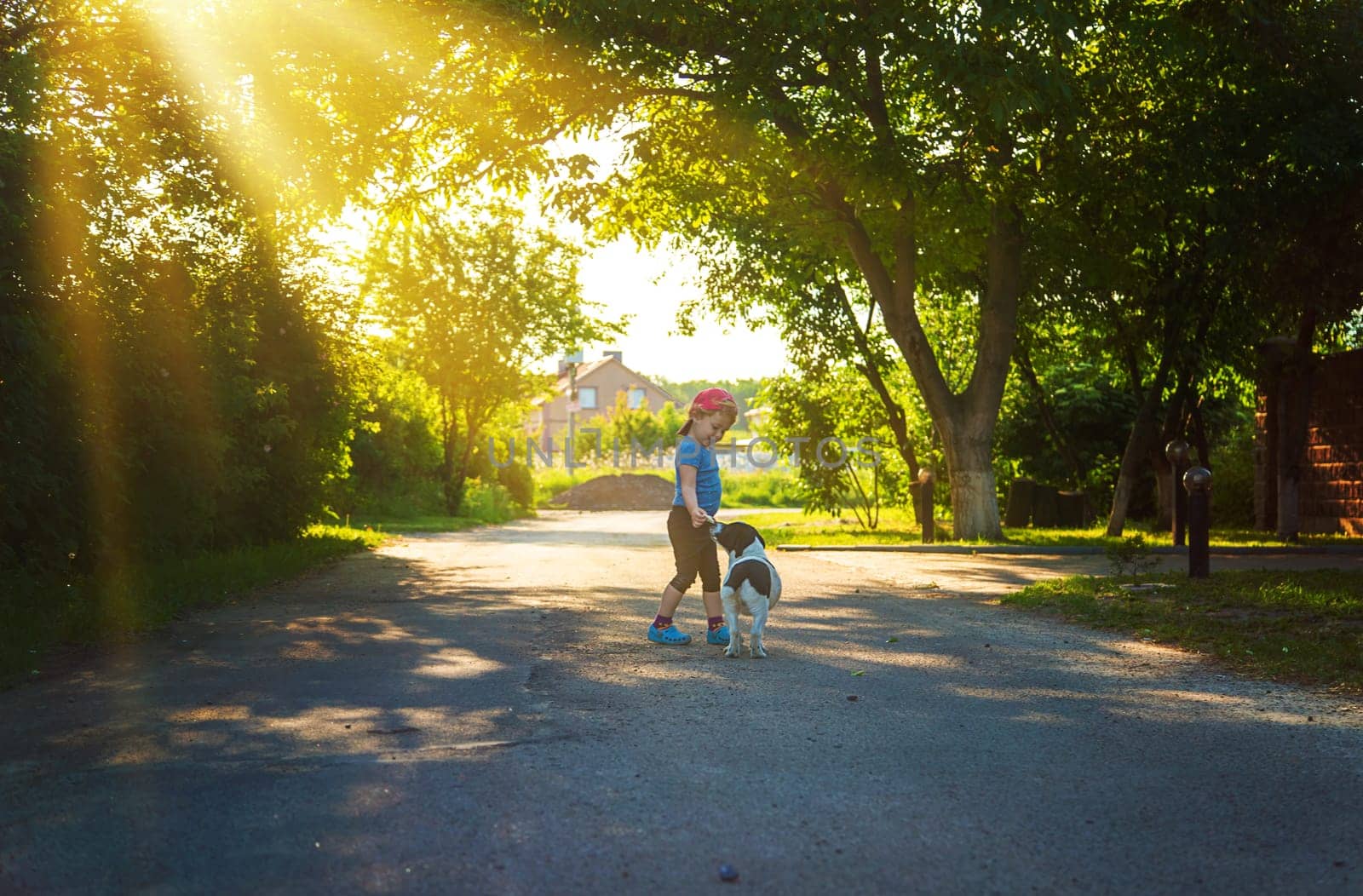 A child plays with a small dog in the park. Selective focus. by yanadjana