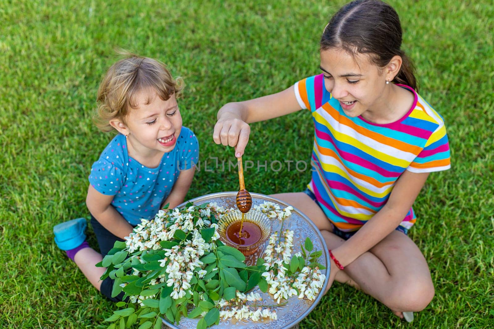 The child eats honey in the garden. Selective focus. Nature.