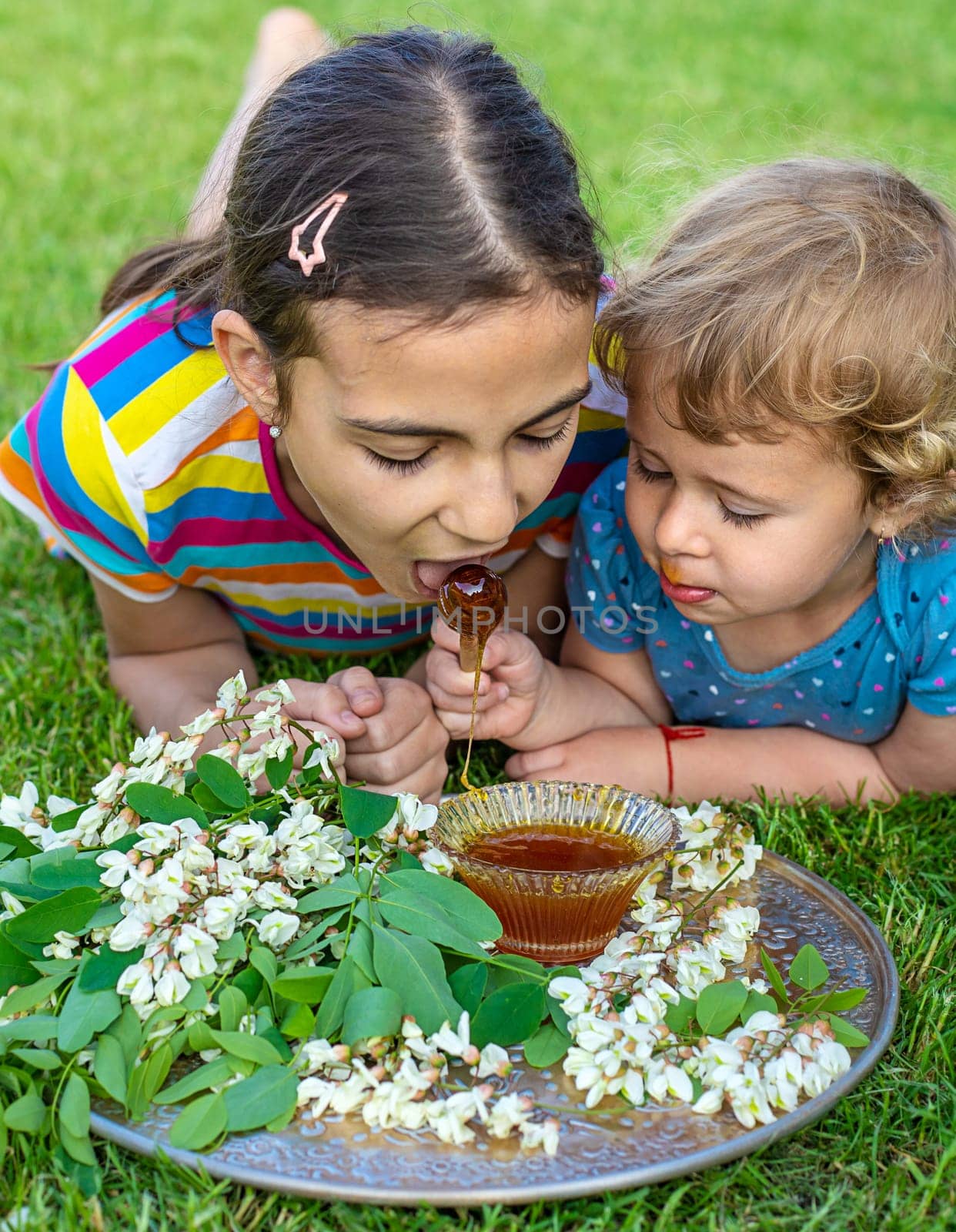 The child eats honey in the garden. Selective focus. Nature.