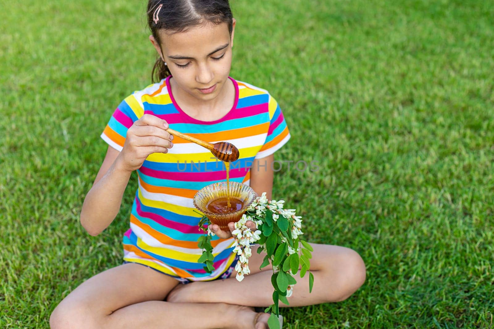 The child eats honey in the garden. Selective focus. by yanadjana
