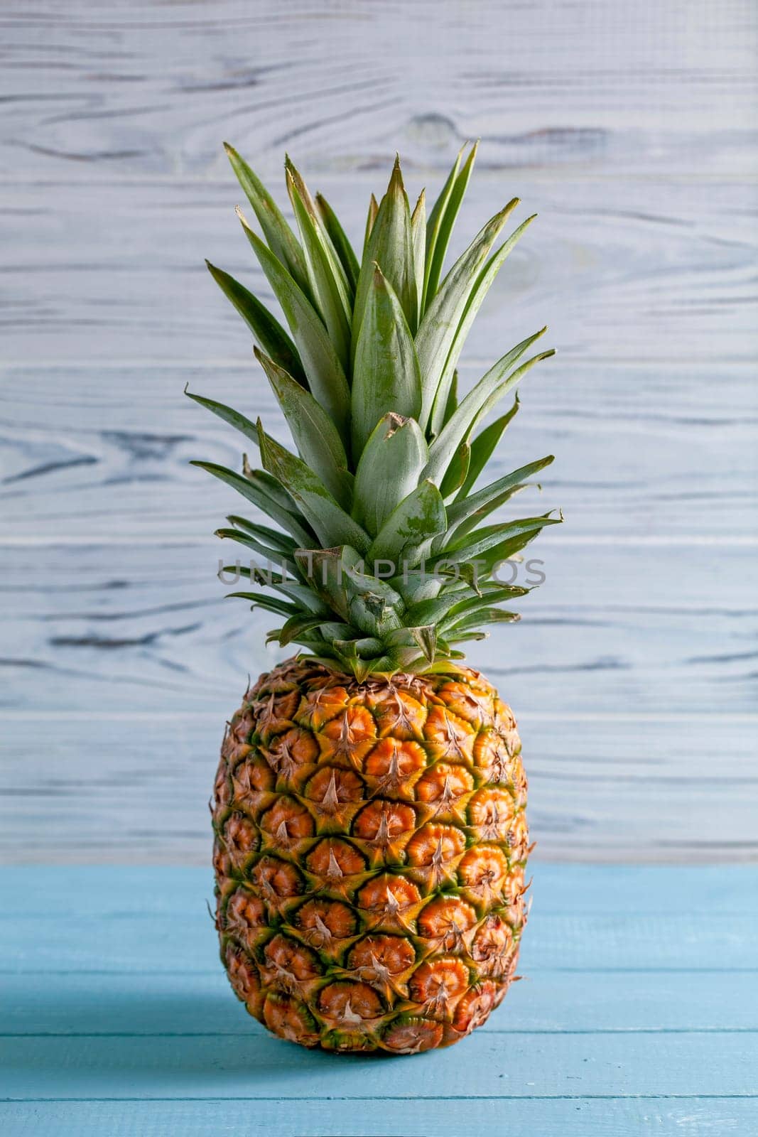 Ripe pineapple on blue background by gcm