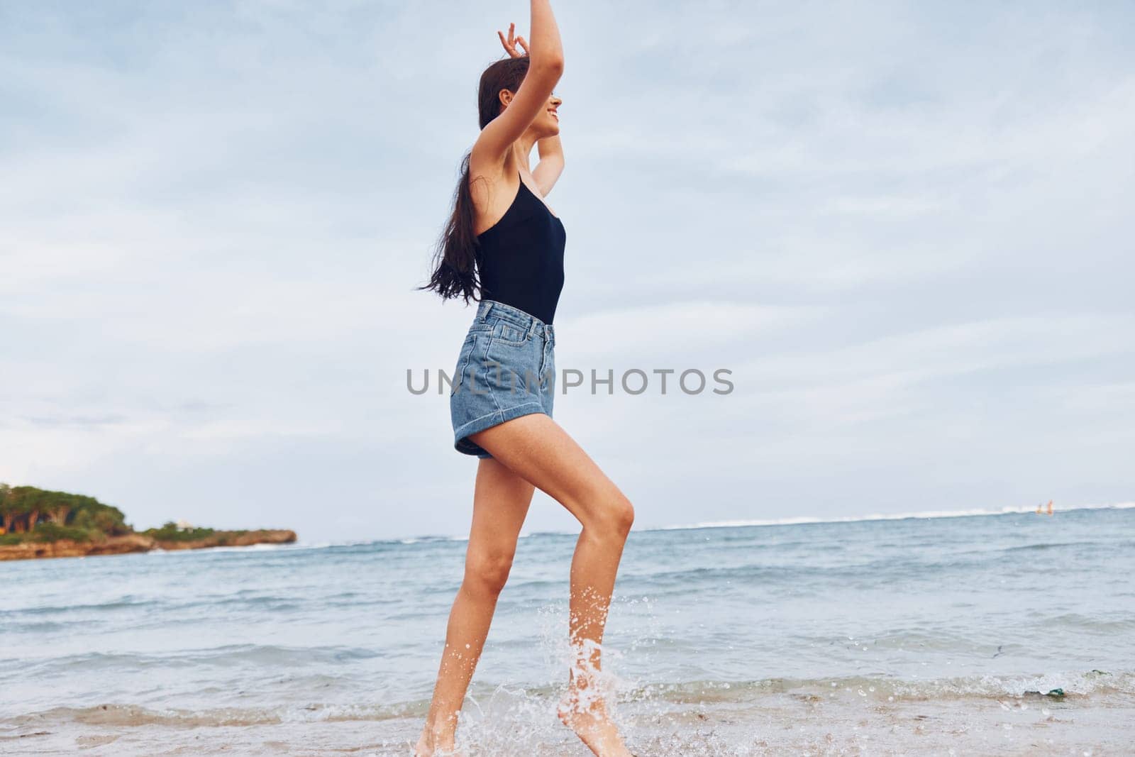 young woman sunset active ocean tan summer nature running sea wave smiling freedom travel positive carefree smile lifestyle beauty beach leisure