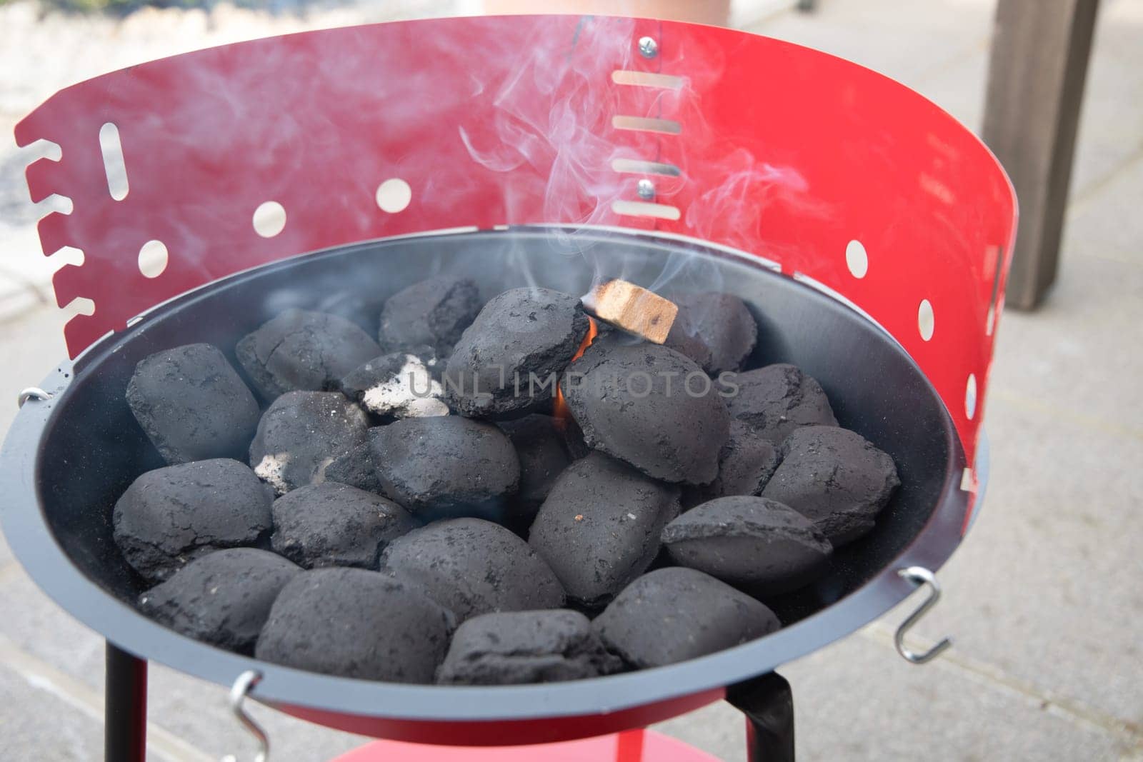 a man lights a fire with a lighter special charcoals for a barbecue a barbecue house on the terrace prepares a place for a barbecue. High quality photo