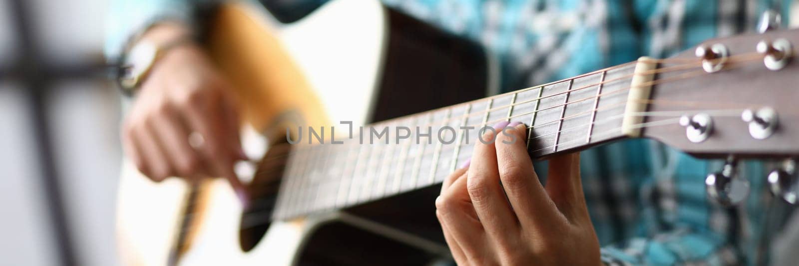 Woman hands playing guitar closeup. Learning to play acoustic guitar by kuprevich