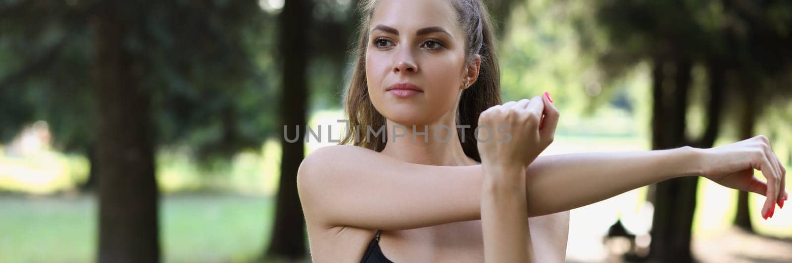 Beautiful young woman doing stretching exercises outdoors. Healthy women and sport concept