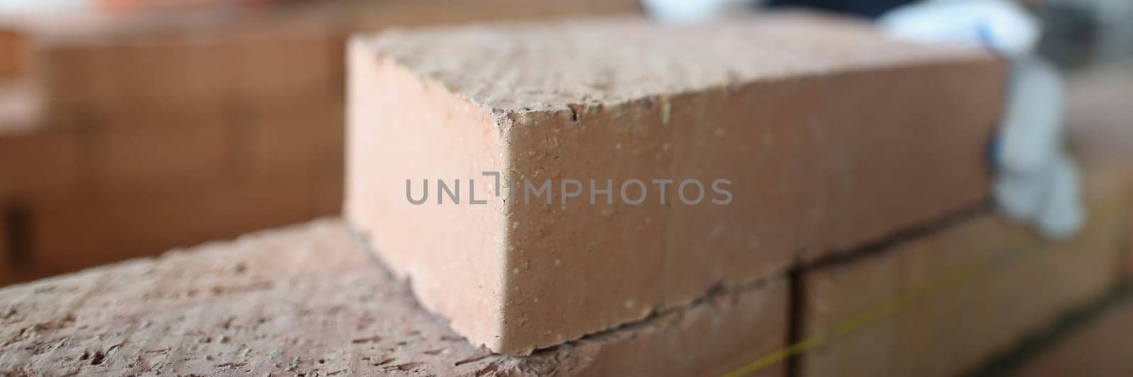 Closeup of industrial bricklayer laying bricks at construction site. Building brick walls concept