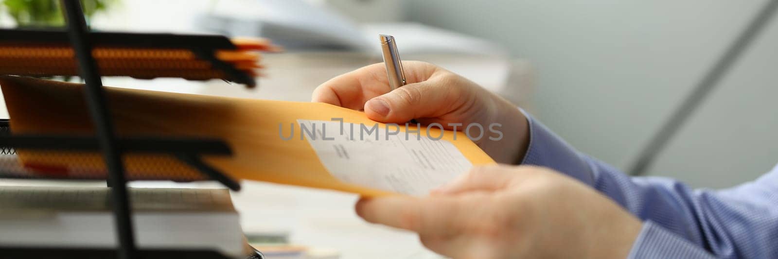 Person picks up yellow envelope with mail at workplace. Types of business correspondence concept