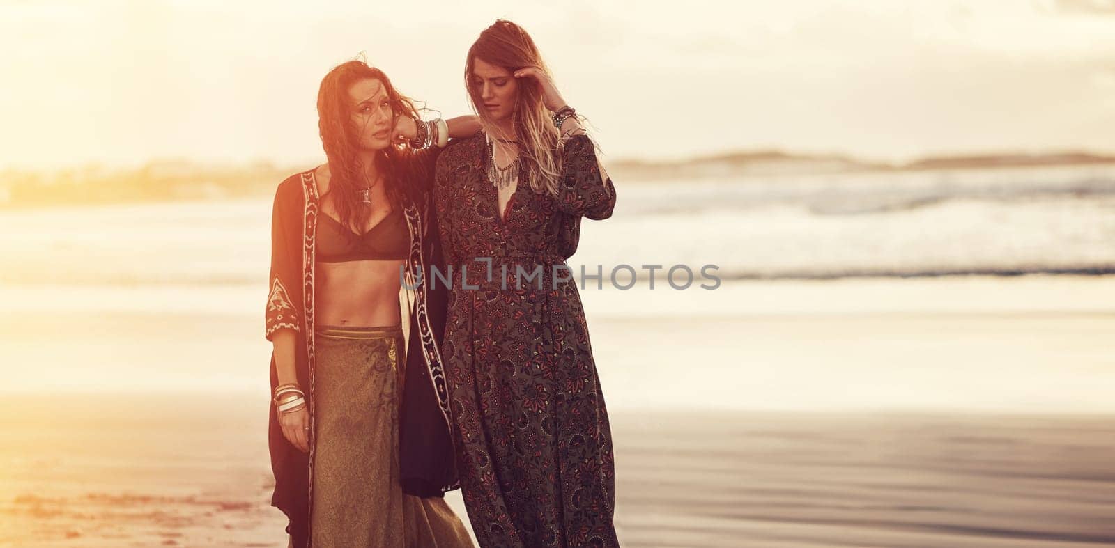 Style has nothing to do with fashion. two young women spending the day at the beach at sunset. by YuriArcurs