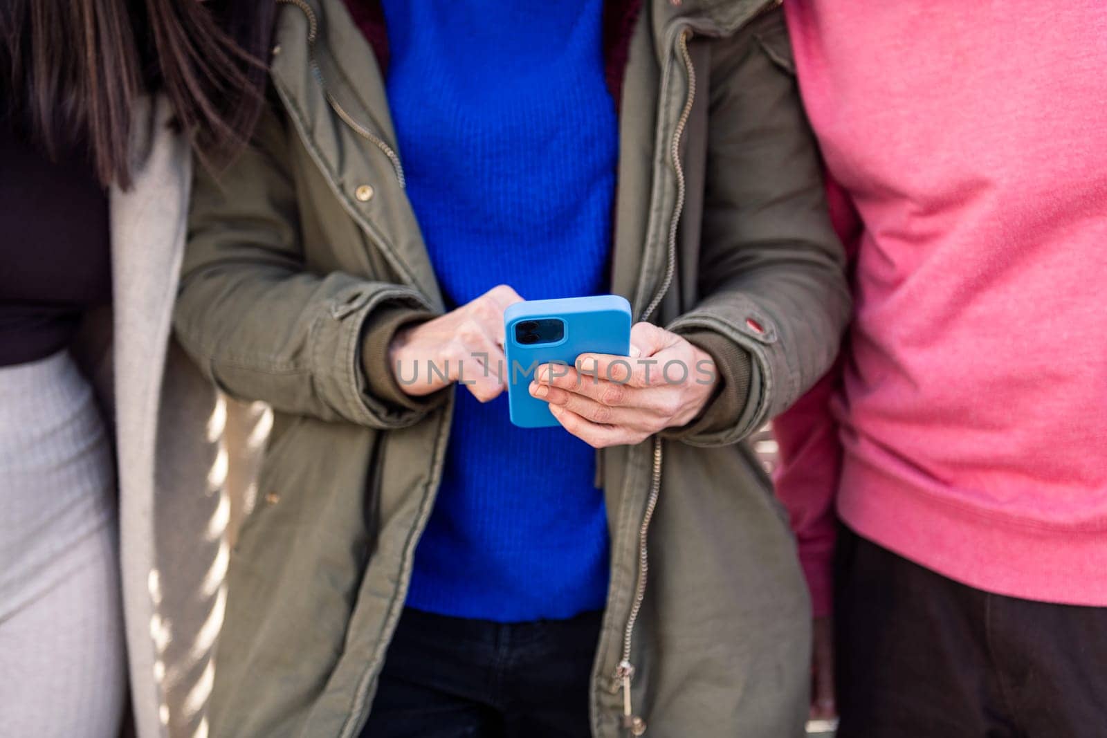 hands of a woman using smart phone with friends by raulmelldo