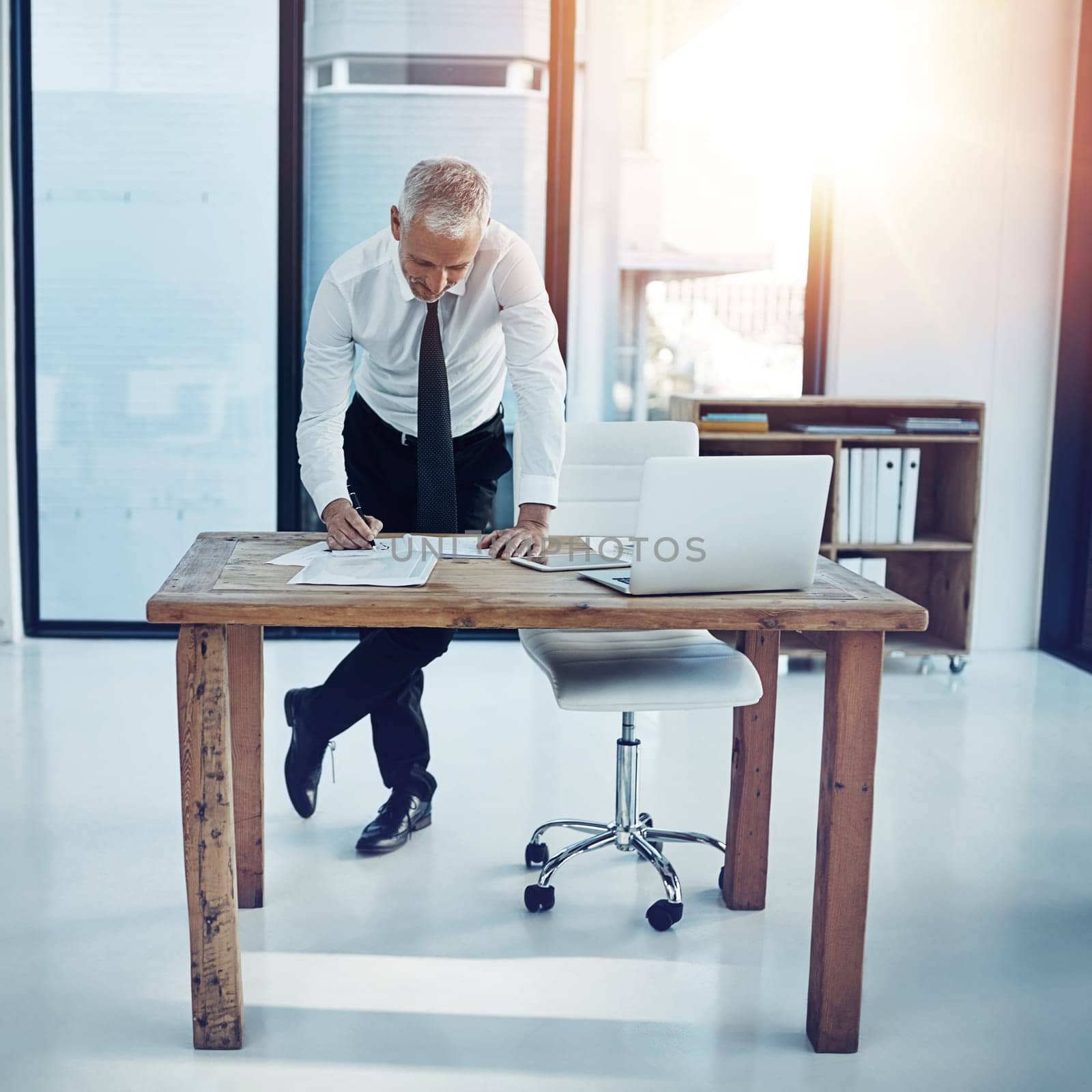 Giving the plans one more look. a businessman working at his desk in an office