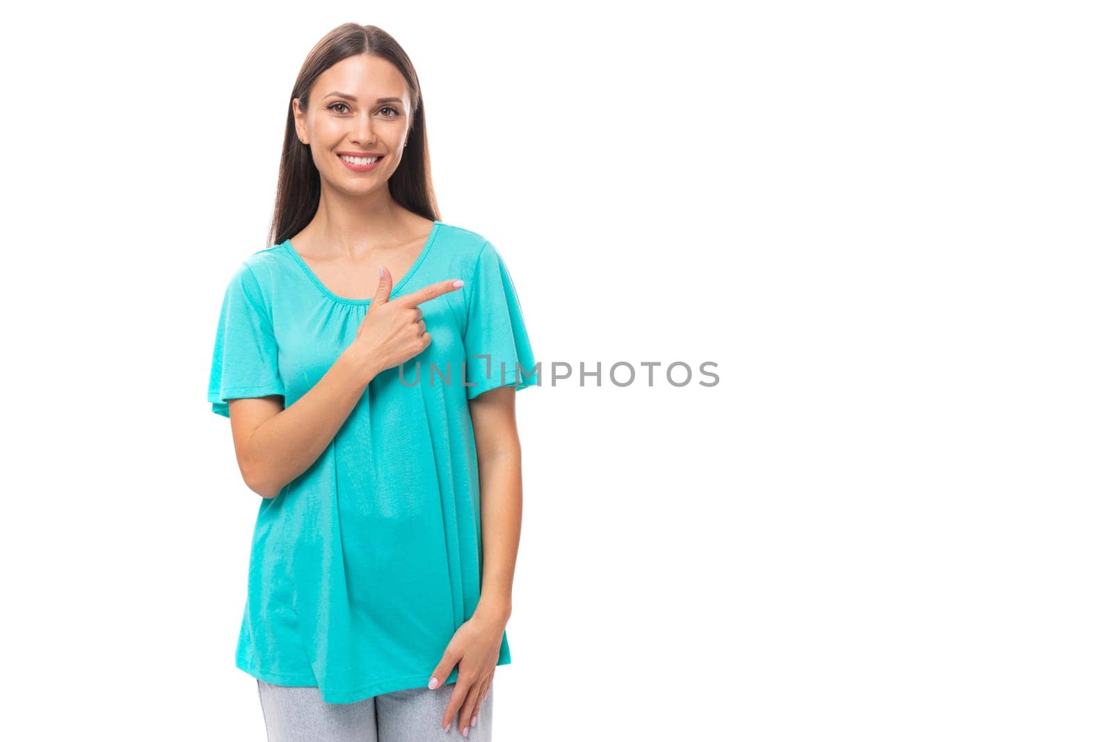 young caucasian female model with black straight hair dressed in a blue t-shirt points with her hands at the advertisement.