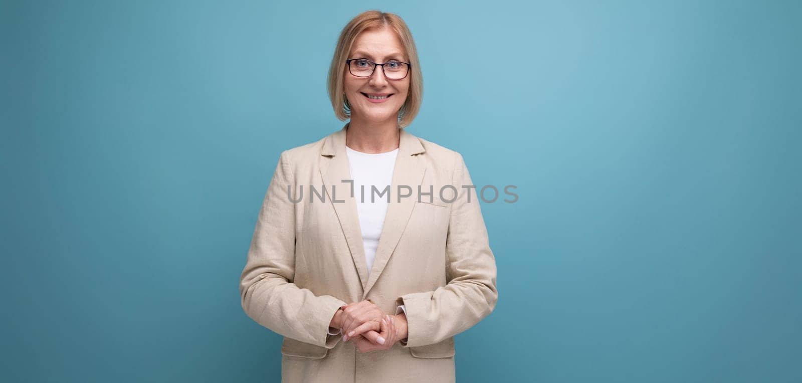 smart adult 50s woman in a stylish jacket on a bright studio background with copy space.