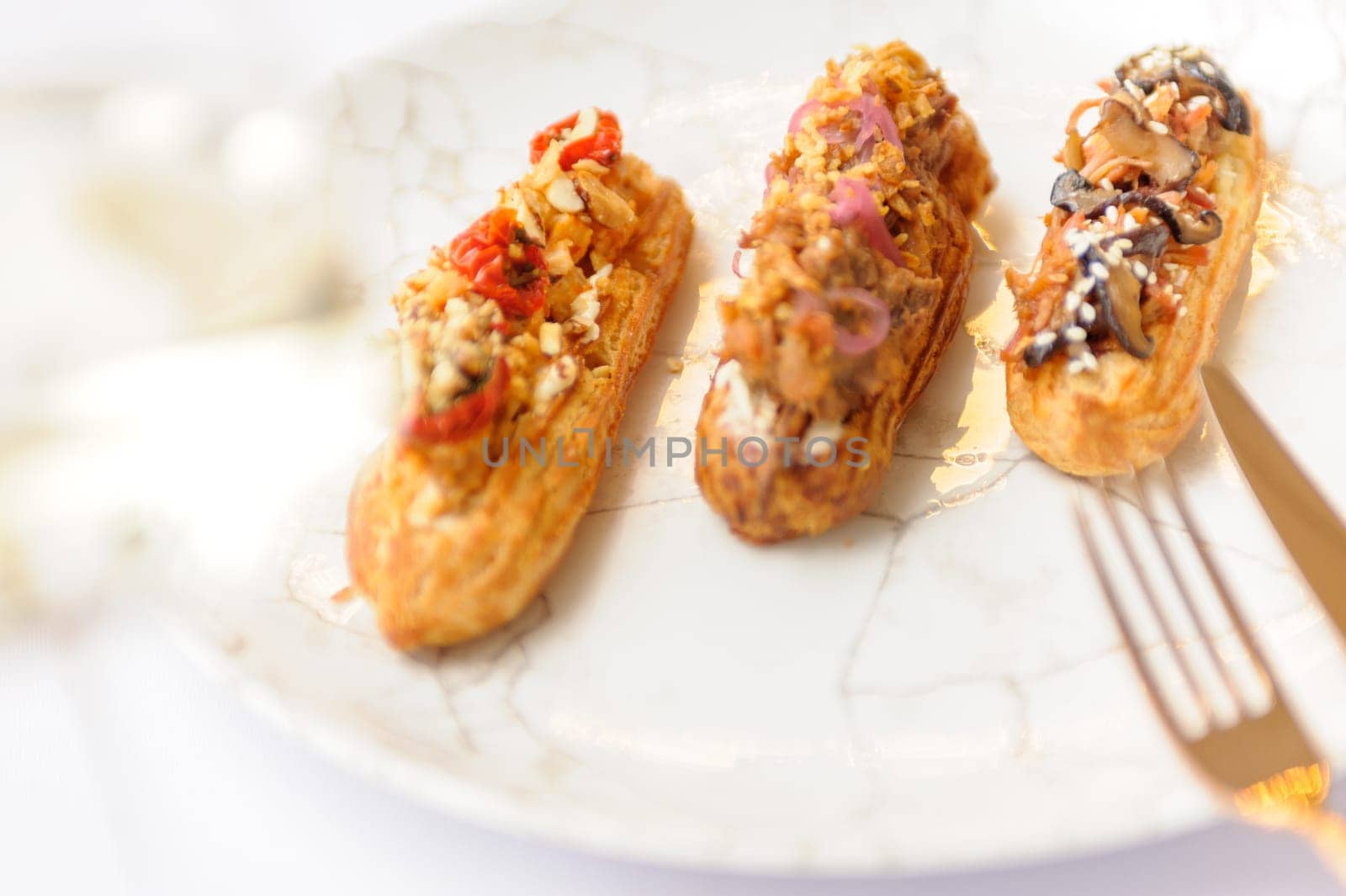 Eclairs with various fillings on a gray plate close up