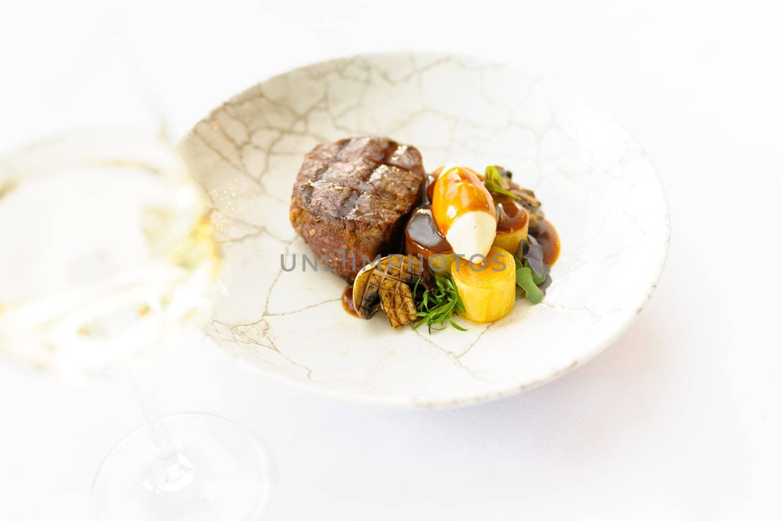 Exquisite serving of beef steak on a white plate on a white background