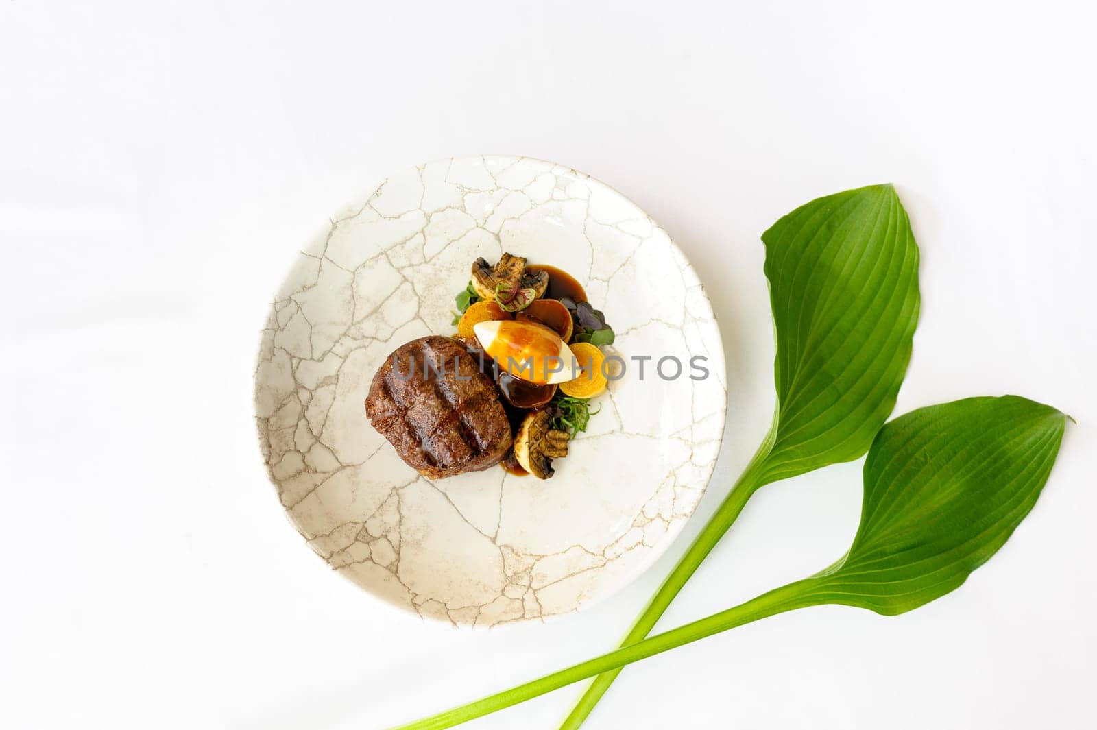 Exquisite serving of beef steak on a white plate on a white background