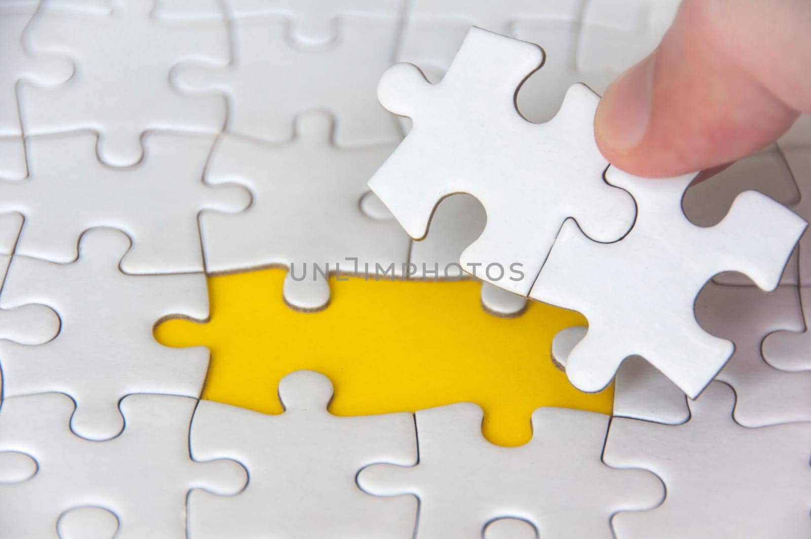 Hand holding separated jigsaw puzzle with customizable space for text. Copy space