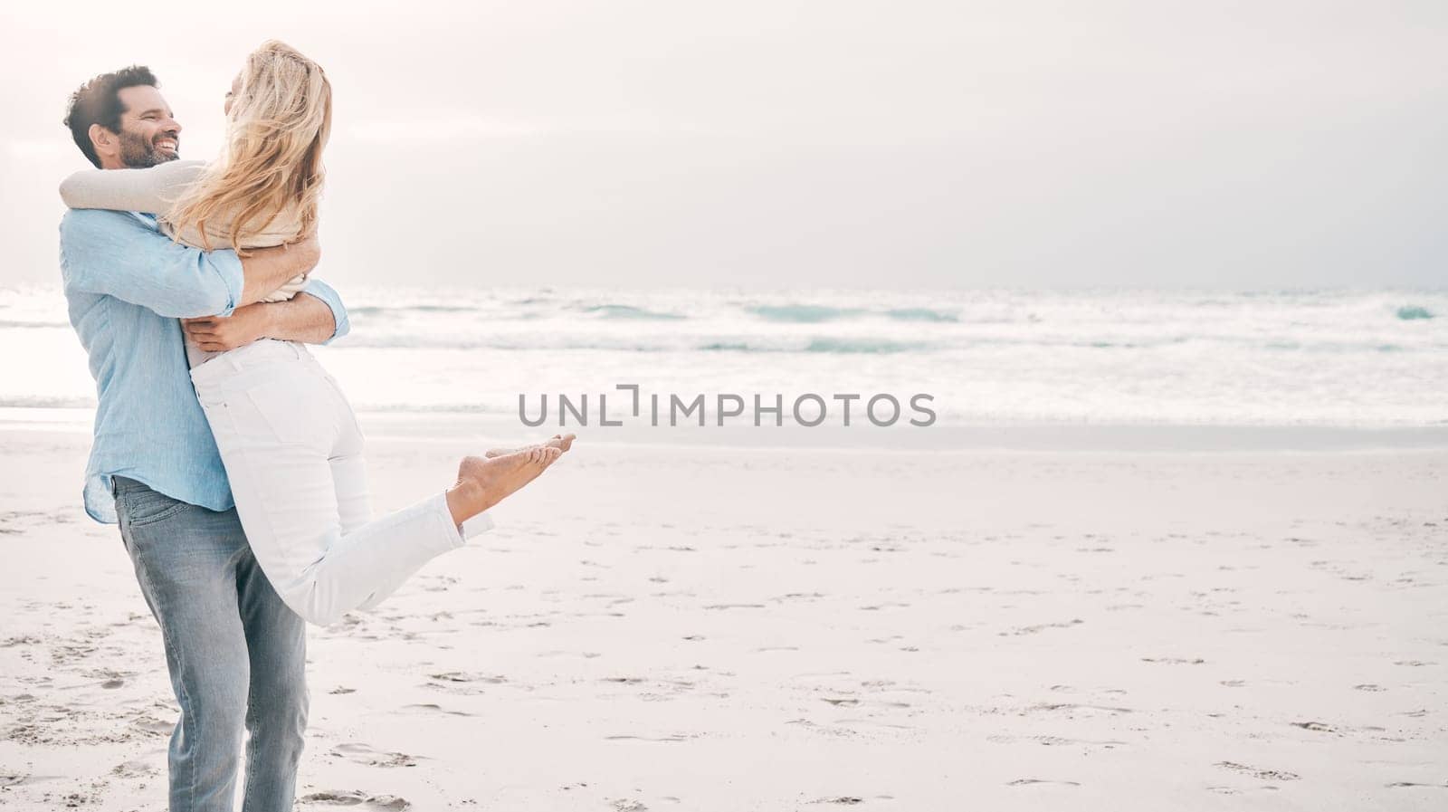 Beach, travel and man carry woman on holiday, vacation and romantic weekend for anniversary. Mockup space, marriage and happy mature couple spin in air for bonding, quality time and romance by ocean.